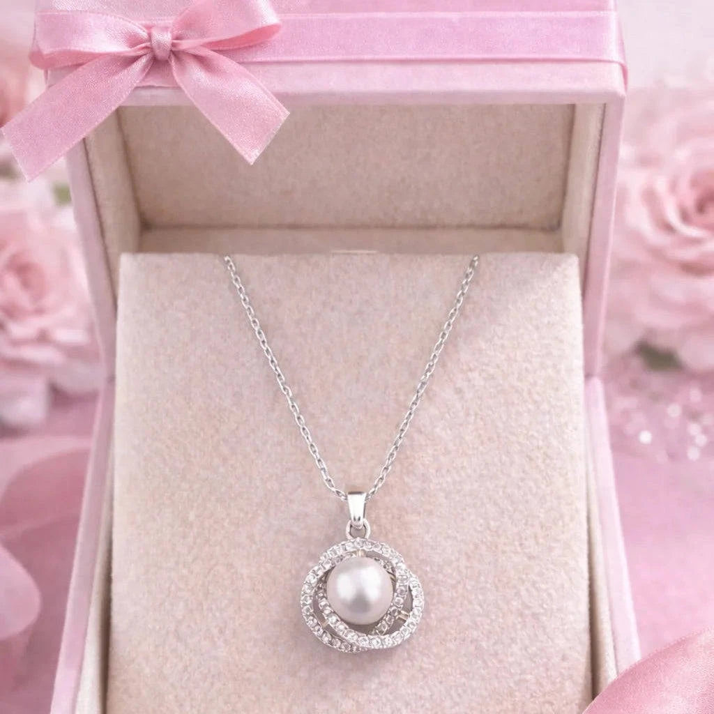 Silver necklace with a pearl pendant in a pink box with a bow