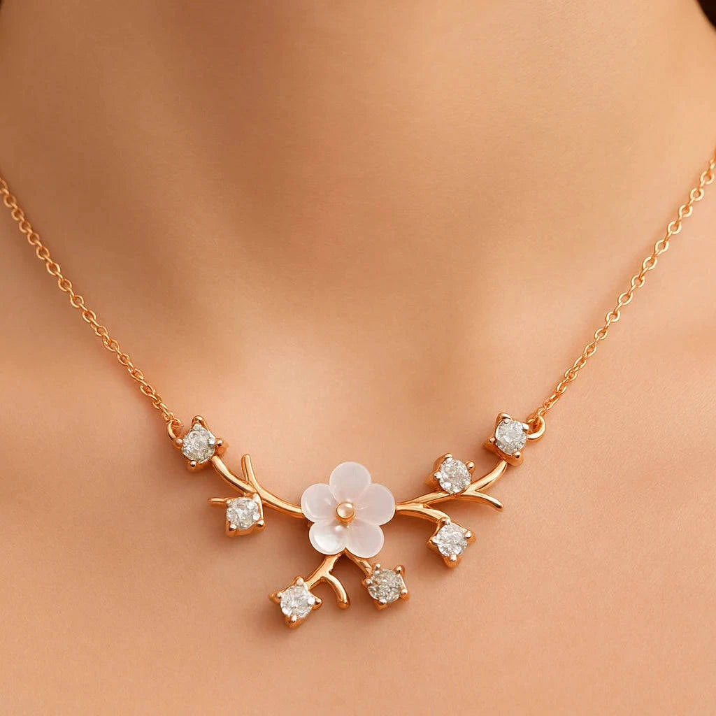 Gold necklace with floral design on a person's neck