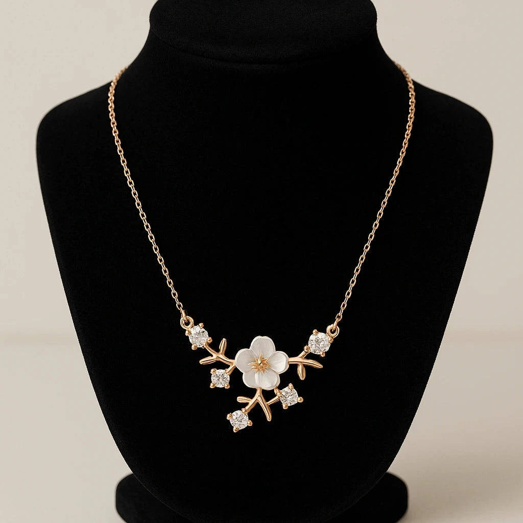 Gold necklace with floral design on a black mannequin bust