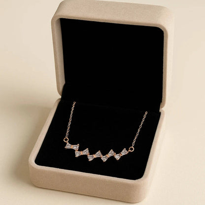 Necklace with diamond accents in a jewelry box on a beige background