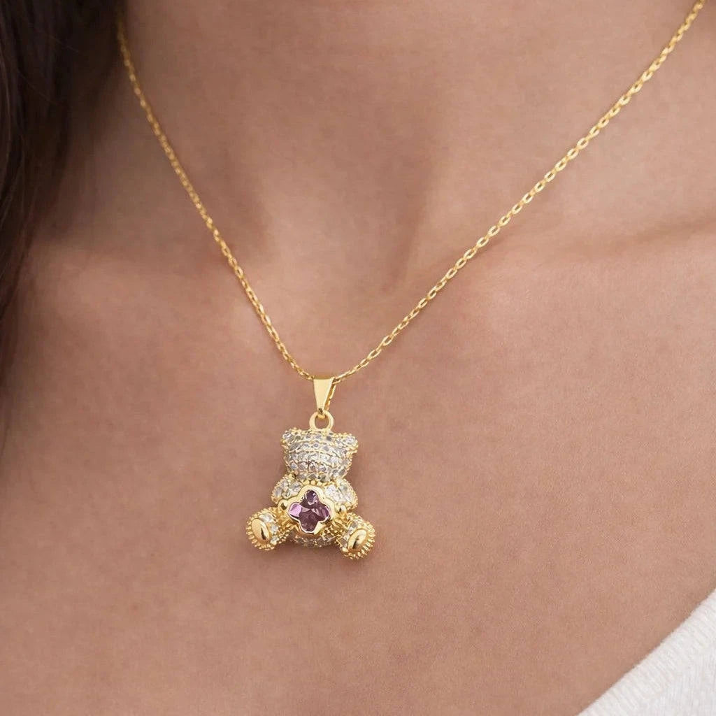 Gold teddy bear pendant necklace on a person's neck