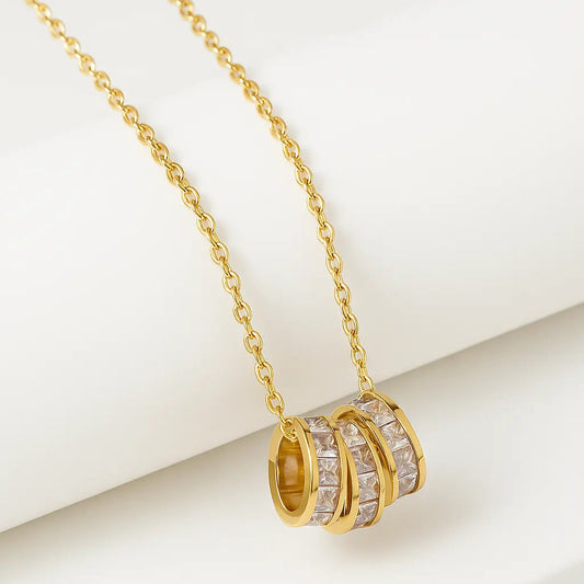 Gold necklace with circular pendants on a white background