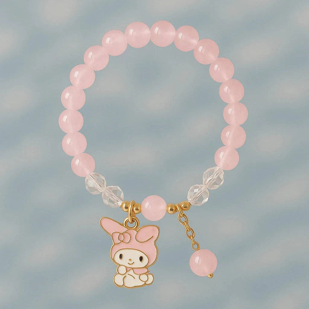 Pink beaded bracelet with a small cartoon character charm on a light blue background
