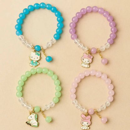 Four colorful beaded bracelets with charms on a beige background