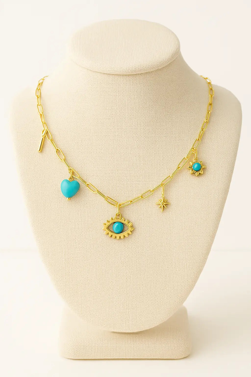 Gold necklace with turquoise heart and eye-shaped charms on a mannequin bust.
