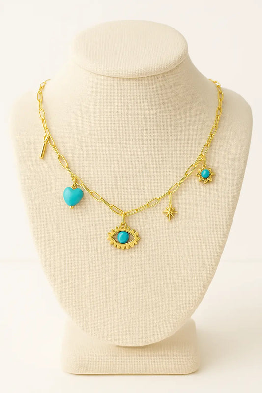 Gold necklace with turquoise heart and eye-shaped charms on a mannequin bust.