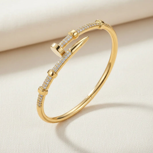 Gold bracelet with diamond accents on a beige background