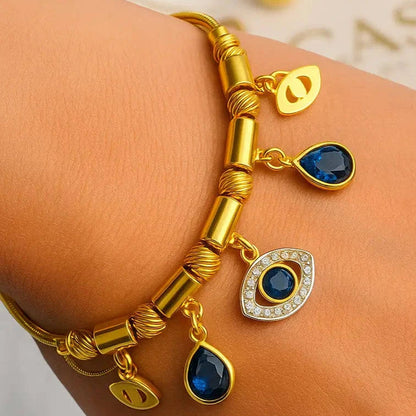 Gold bracelet with blue gemstones on a wrist against a light background
