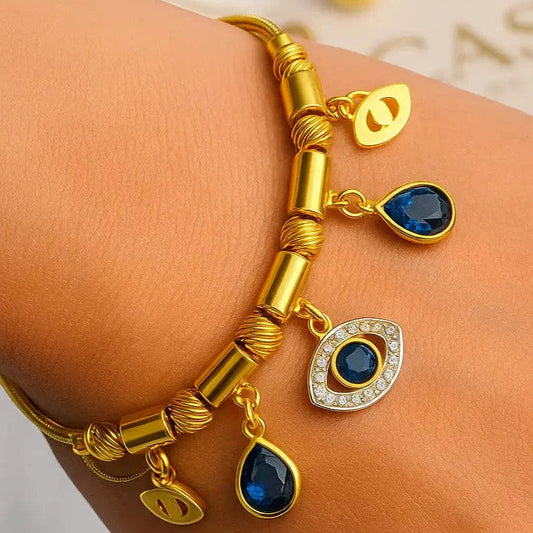 Gold bracelet with blue gemstones on a wrist against a light background