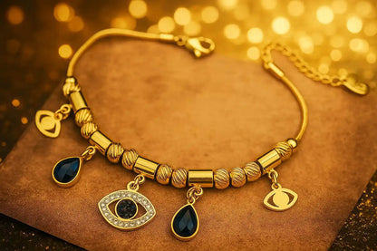 Gold bracelet with eye-shaped charms on a gold background