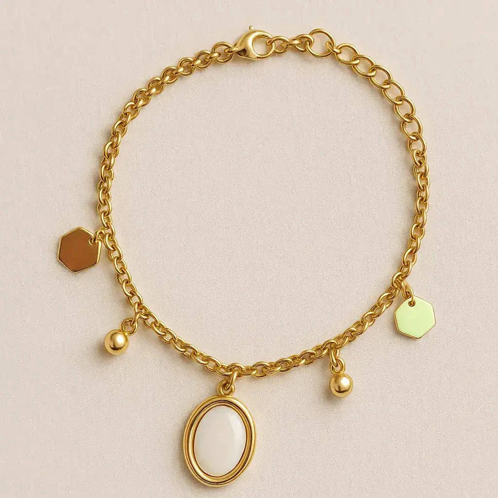 Gold bracelet with various charms on a beige background