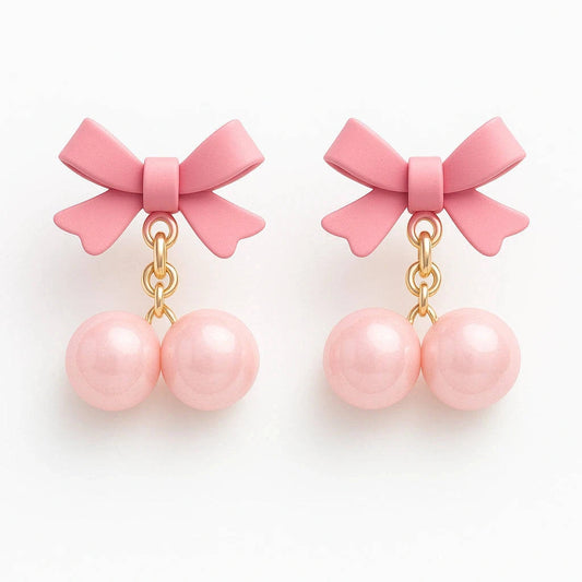 Pair of pink bow earrings with pearl-like beads on a white background