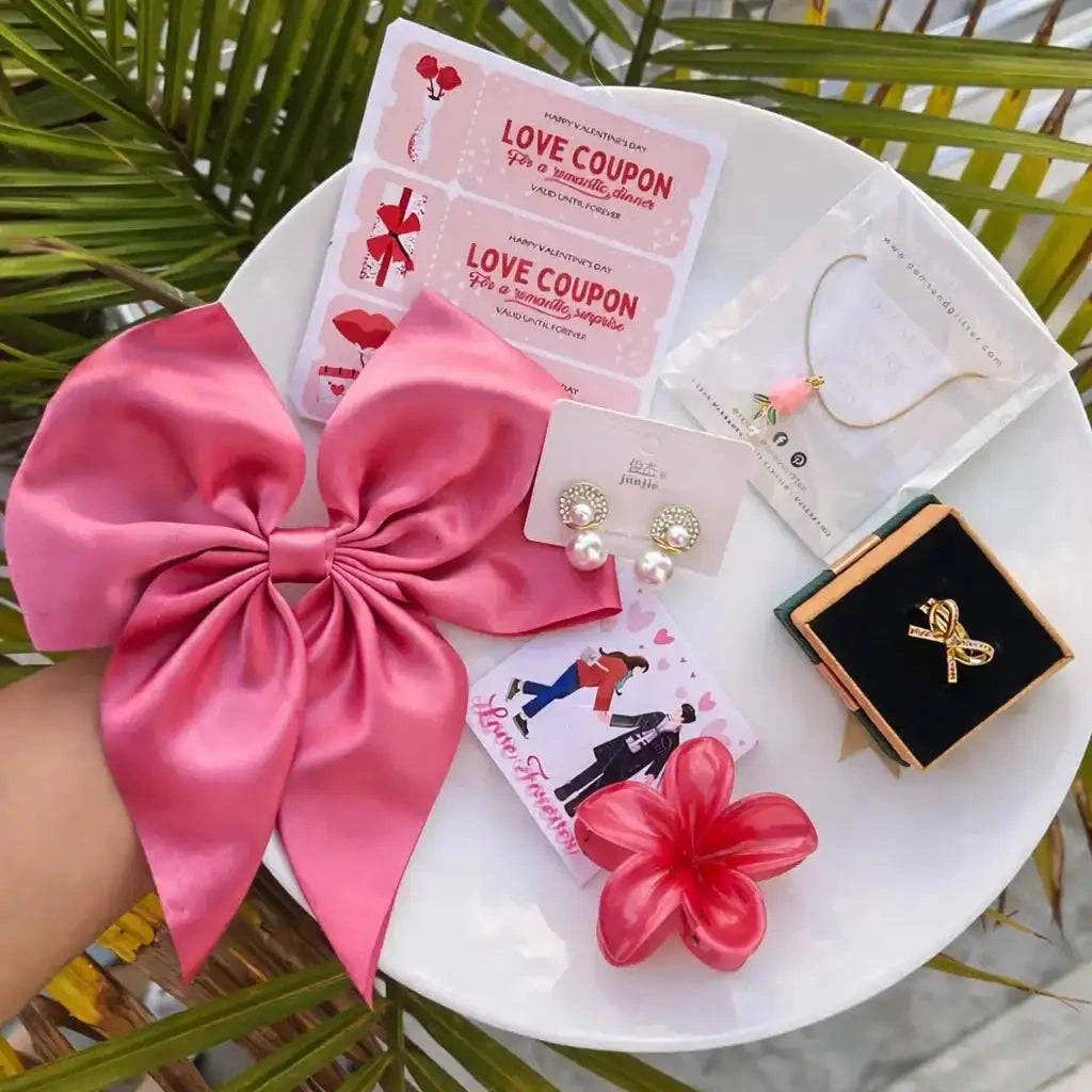 Table with pink bow, earrings, and other items with a green leafy background